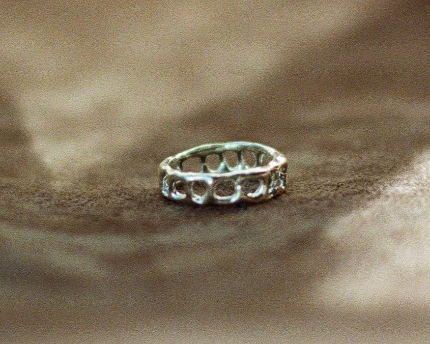 Silver ring on a textured surface with a blurred background
