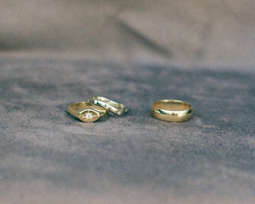 Three gold rings on a textured gray surface