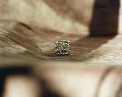 Close up of three stacked silver rings on a brown blurred background
