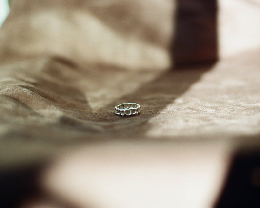 Silver ring on a textured surface with a blurred background