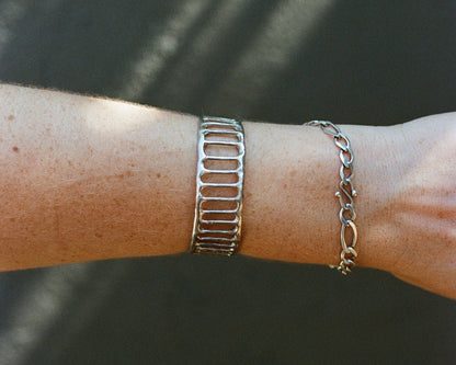 Silver bracelet on a wrist with a blurred background