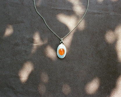 Pendant necklace with a carnelian stone on a blurred background