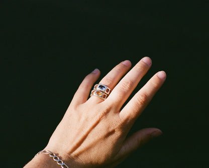 Hand wearing a two rings with a dark background