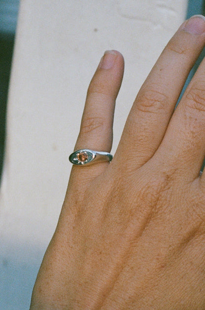 Close-up of a hand wearing a silver ring with a cushion cut pink tourmaline.