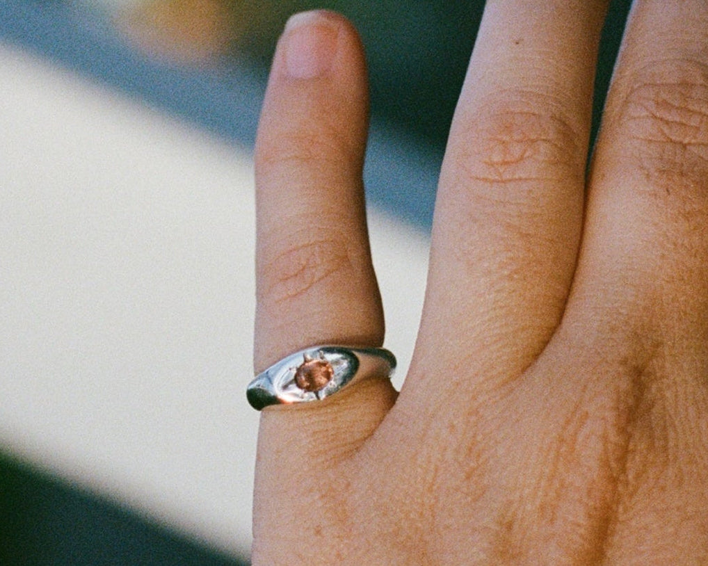 Close-up of a hand wearing a silver ring with a cushion cut pink tourmaline.