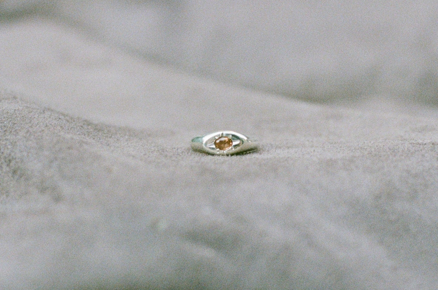 Silver ring with a pink tourmaline on a textured surface