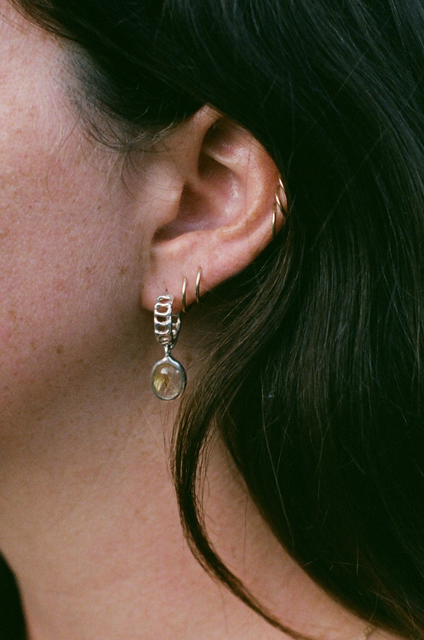 Close-up of a person wearing an earring with a blurred background