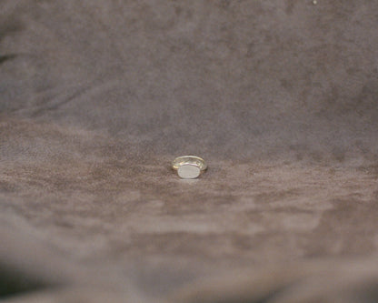 Silver ring on a textured brown fabric surface