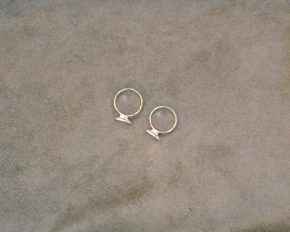 Pair of silver rings on a textured beige surface