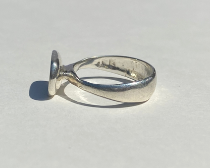 Silver ring on a light gray background