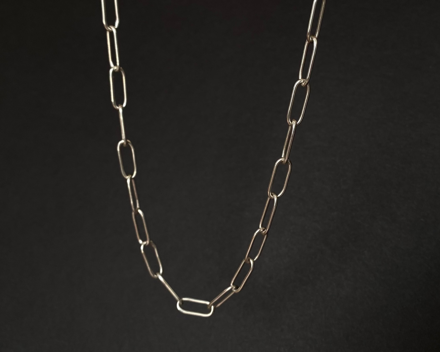 Silver chain necklace on a black background