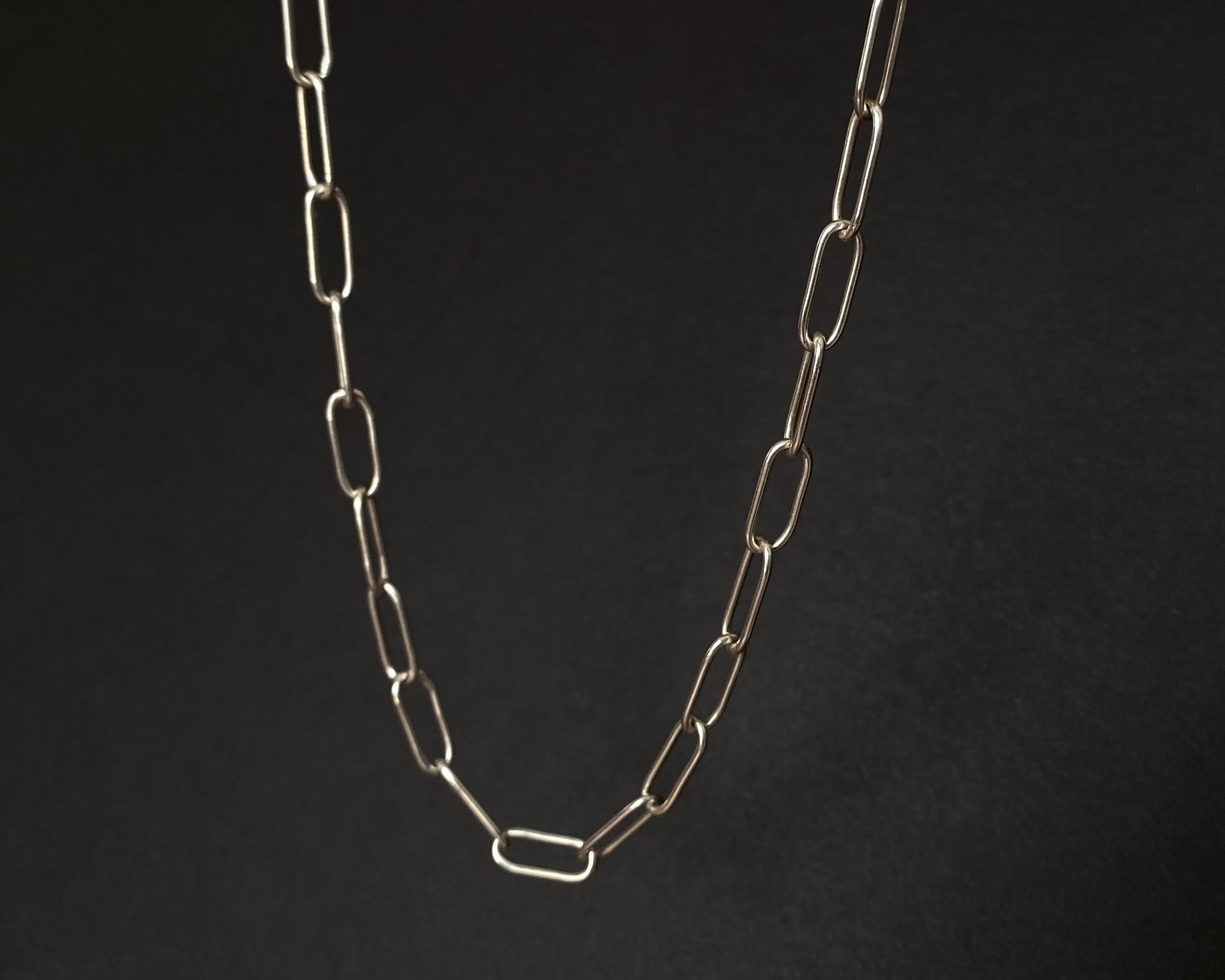 Silver chain necklace on a black background