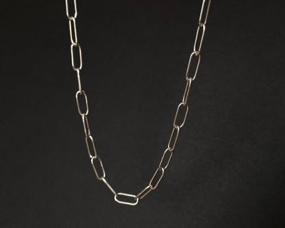 Silver chain necklace on a black background