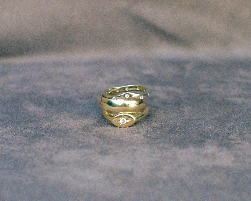 Three gold rings stacked on a textured background