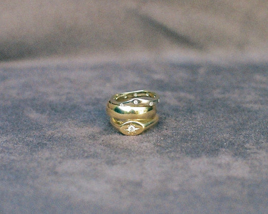 Three gold rings stacked on a textured background