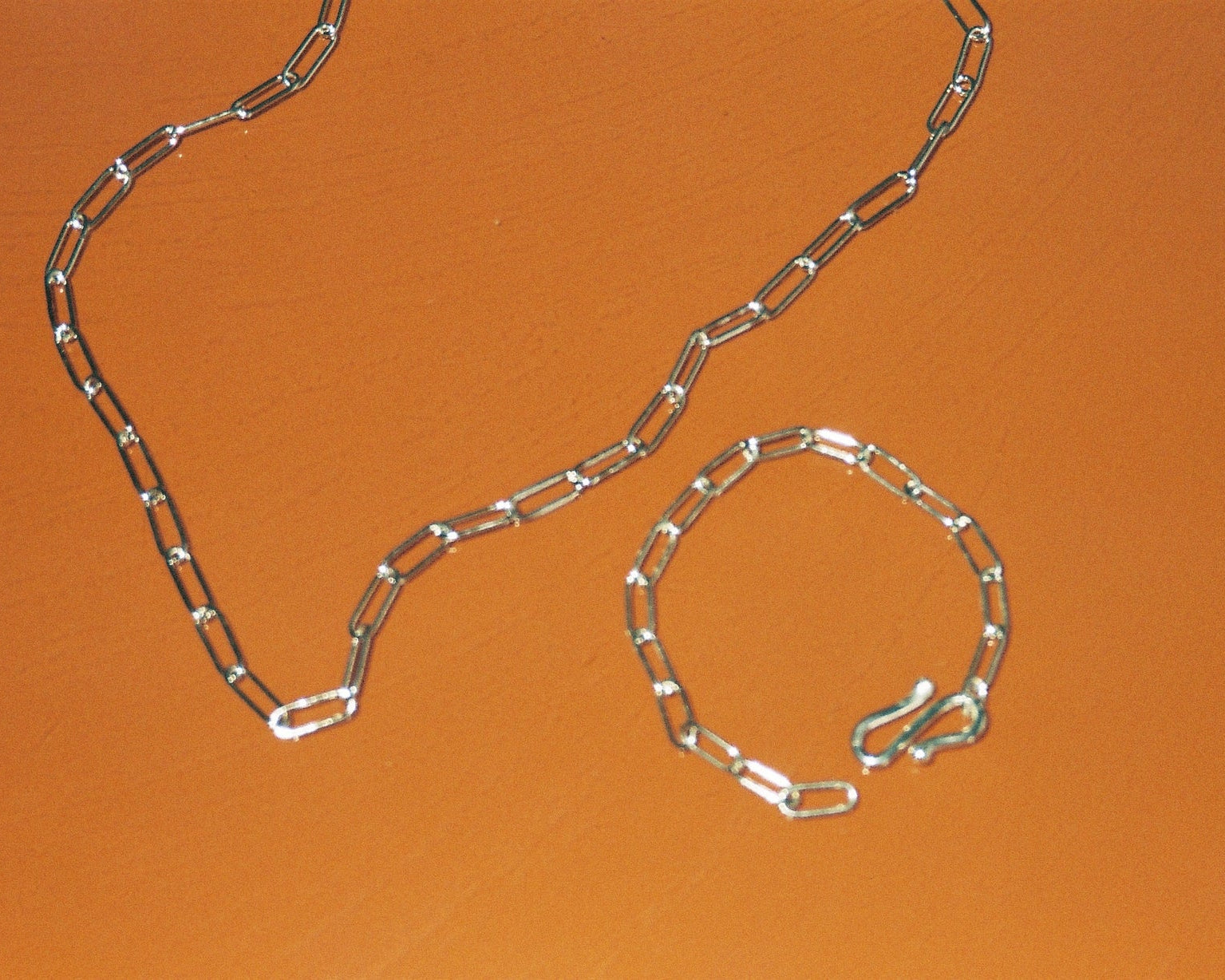 Sterling silver chain against an orange background